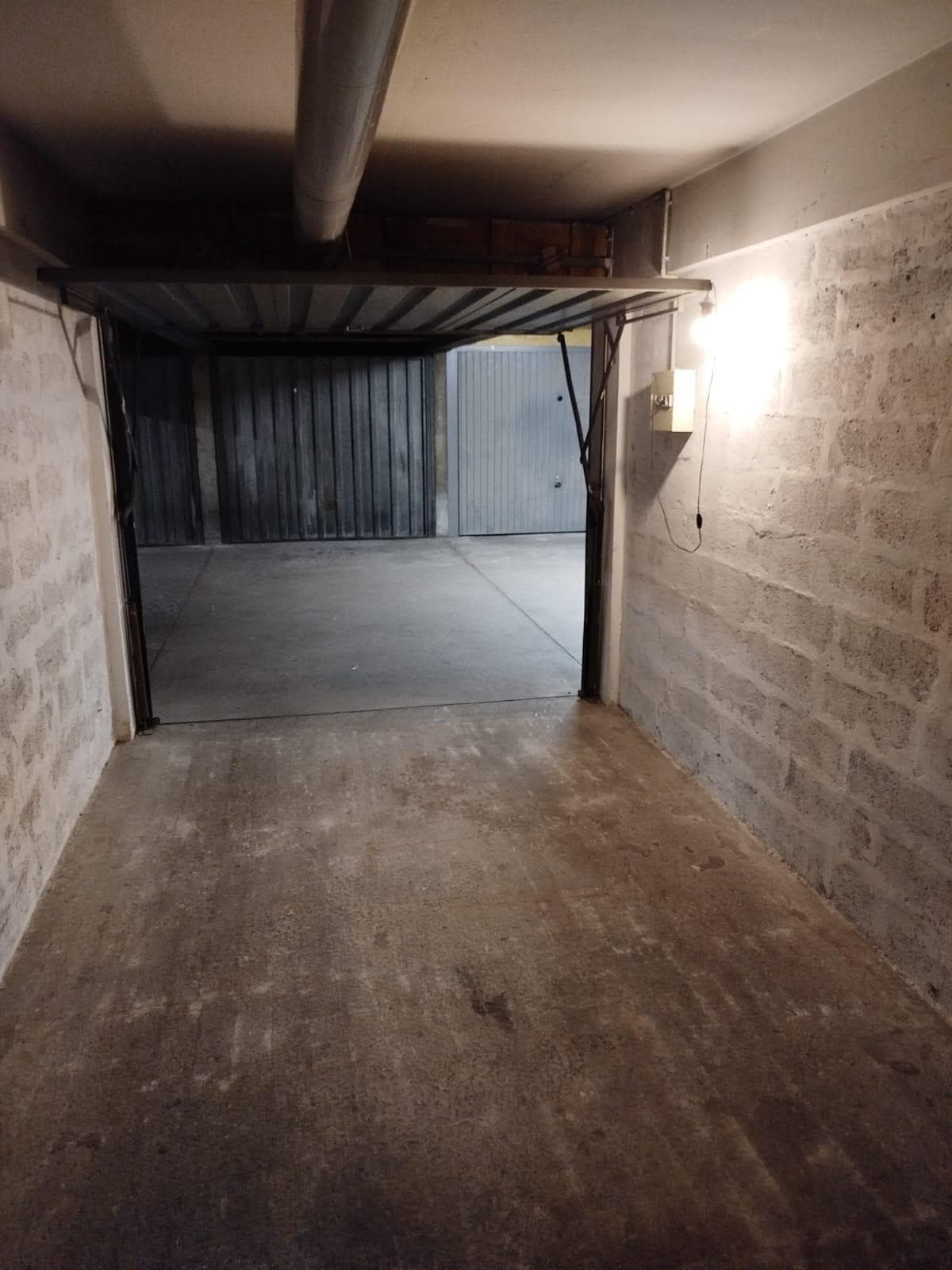 Garage fermé à louer à Villeurbanne près de Laurent Bonnevay, porte basculante ouverte et éclairage